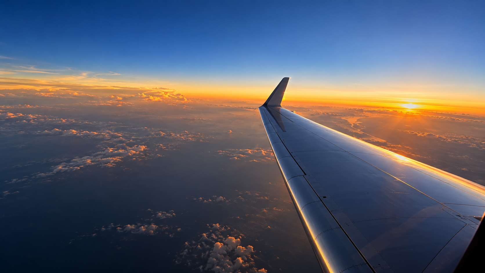 The view from an aircraft above the clouds at sunset